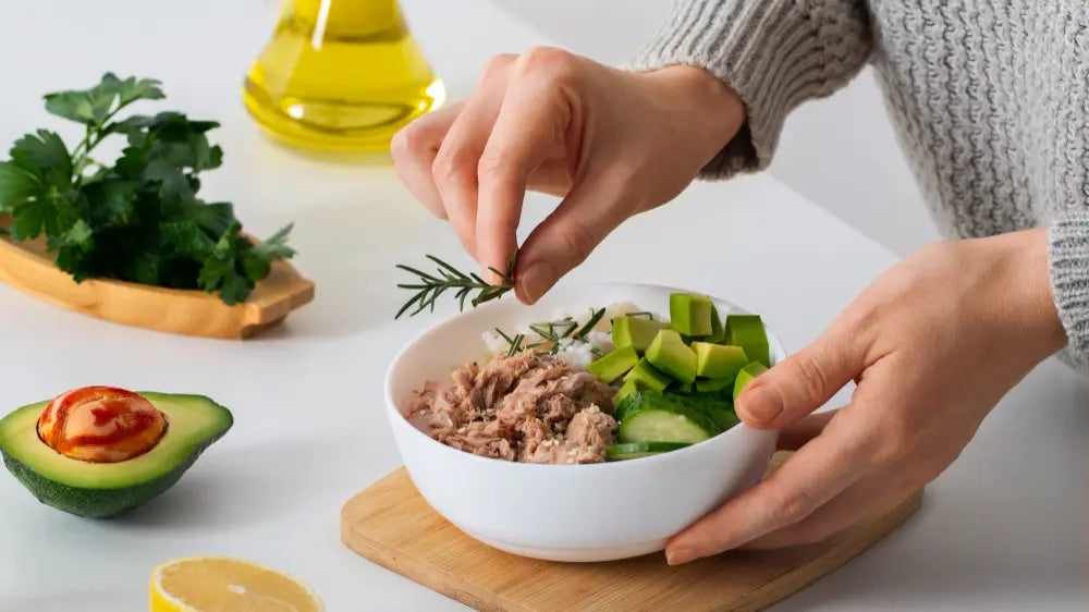 Pessoa segurando alecrim em cima de tigela com alimentos low carb