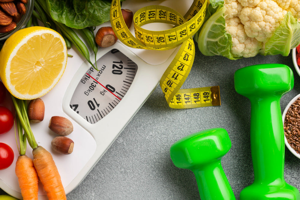 Imagem com alimentos saudáveis, halteres, fita métrica e balança para ilustrar o conteúdo sobre cutting e bulking