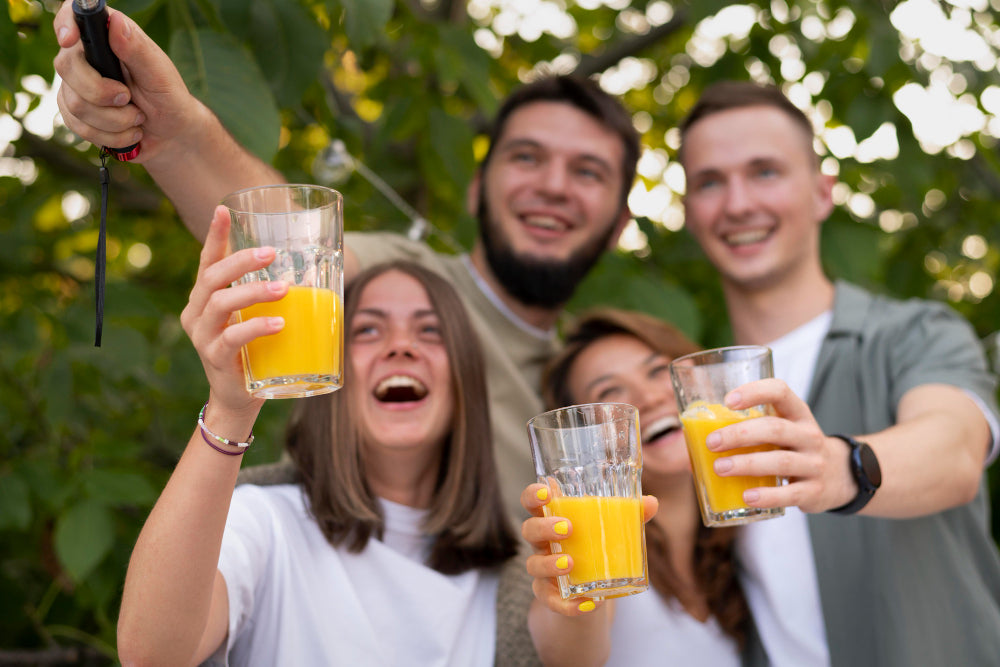 grupo de jovens fazendo uma selfie enquanto seguram copos com bebidas durante o fim de ano
