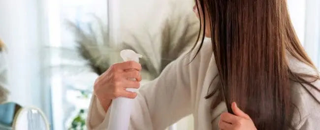 Mulher usando spray com vinagre de maçã para cuidar do seu cabelo