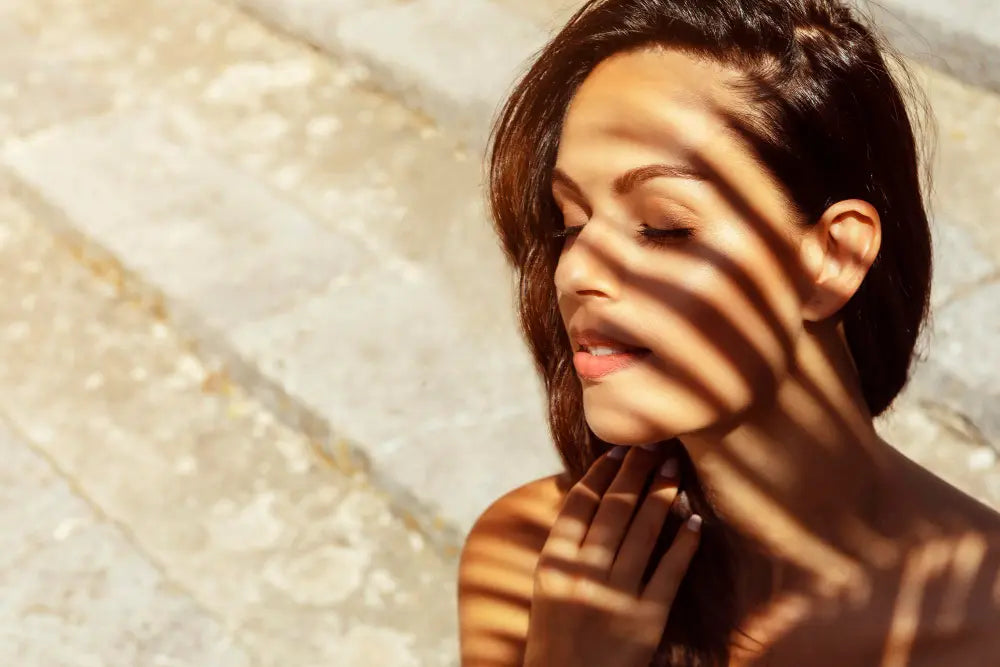 Mulher tomando cuidado com a pele debaixo da luz do sol em sombra
