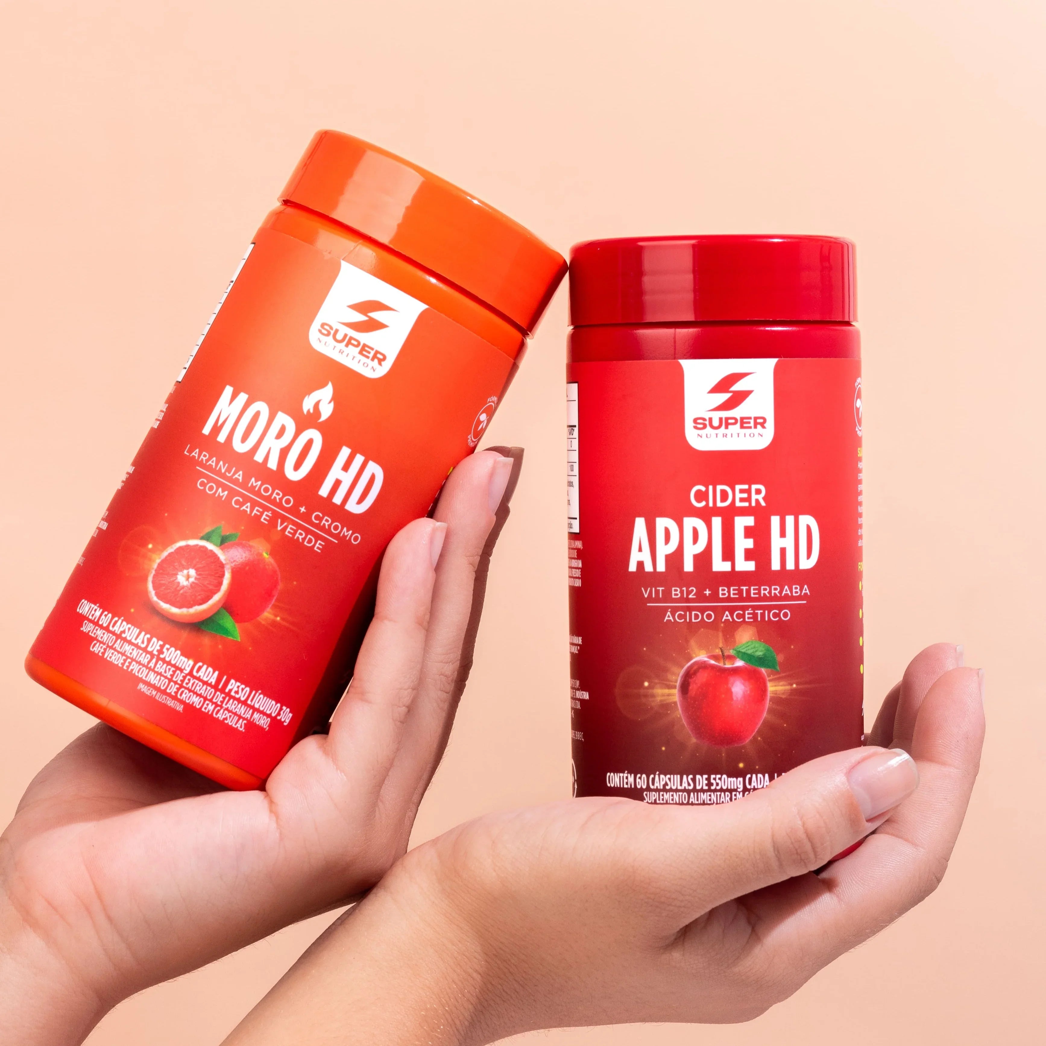 Moro HD e Cider Apple HD em cápsulas, suplementos alimentares da Super Nutrition segurados em mãos