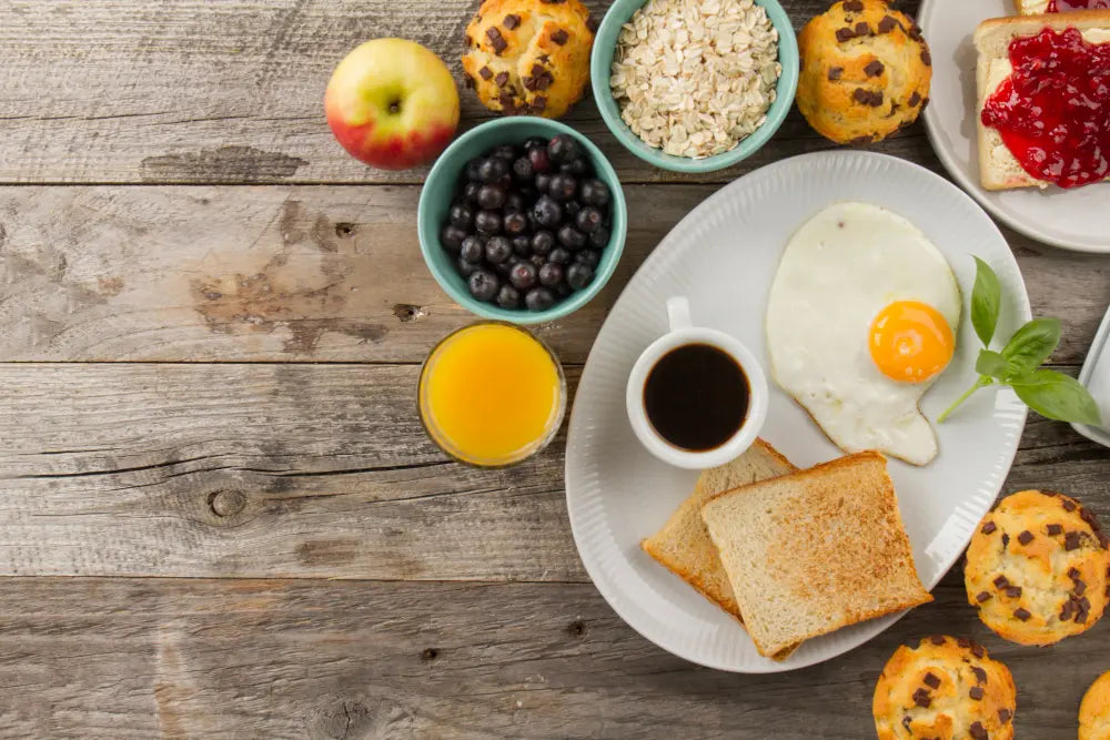 Visão de cima de alimentos de café da manhã em superfície de madeira