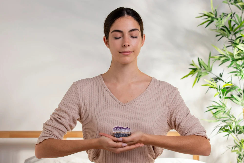 Mulher meditando segurando cristal roxo