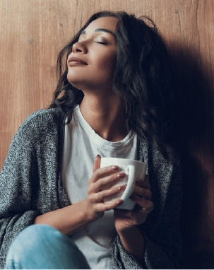 Mulher sentindo o aroma delicioso de Desinchá Noite Sabores