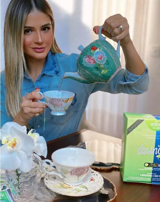 Mulher começando o dia com o preparo de um sachê de Desinchá