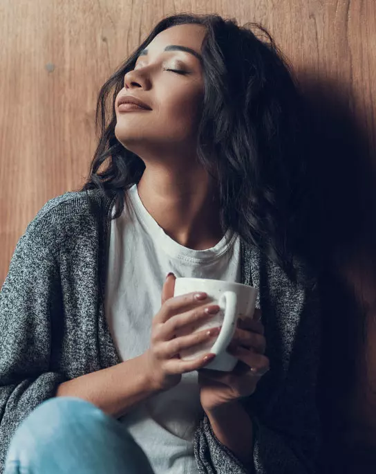 Mulher tomando Desinchá Noite para relaxar antes de dormir