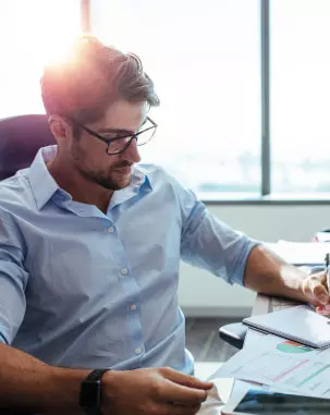 Homem analisando papéis enquanto trabalha