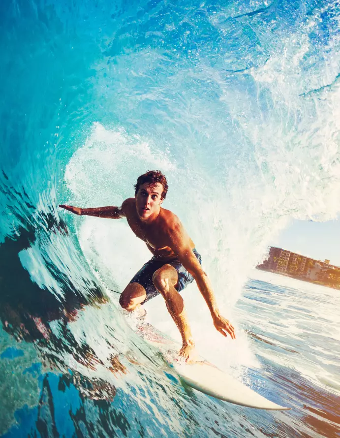 Homem surfando cheio de energia após tomar Desincoffee Energia Extrema da Desinchá