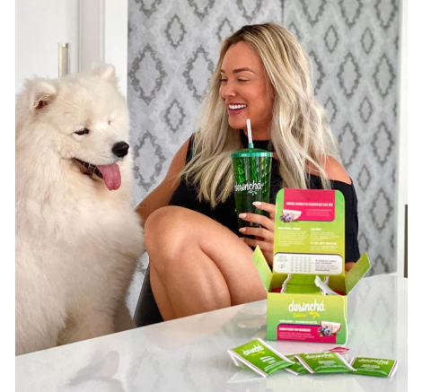 Mulher tomando chá gelado de pitaya com blueberry na companhia do cão de estimação